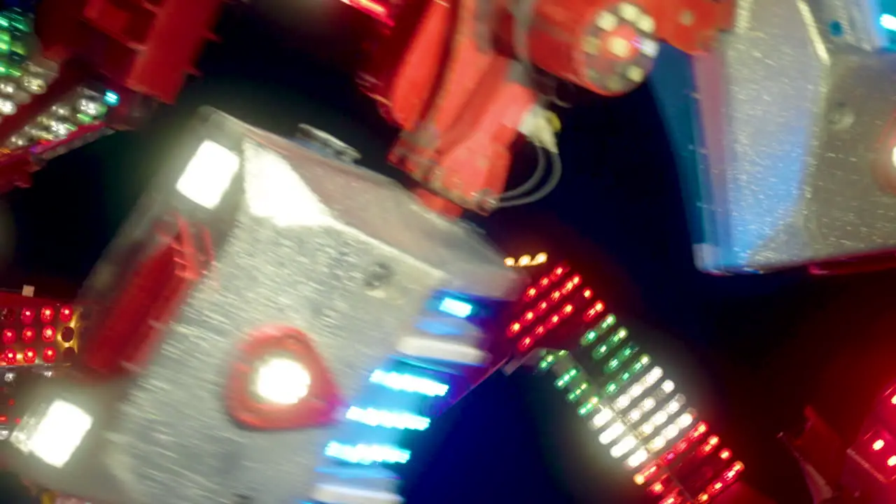 Colorful neon lights glow as people enjoy the rush of an evening ride at the fair