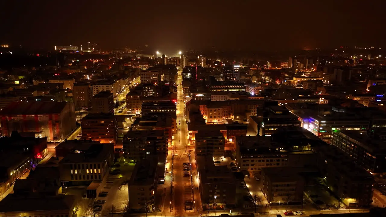 Drone shot of quiet night lit streets of downtown Oulu winter evening in Finland