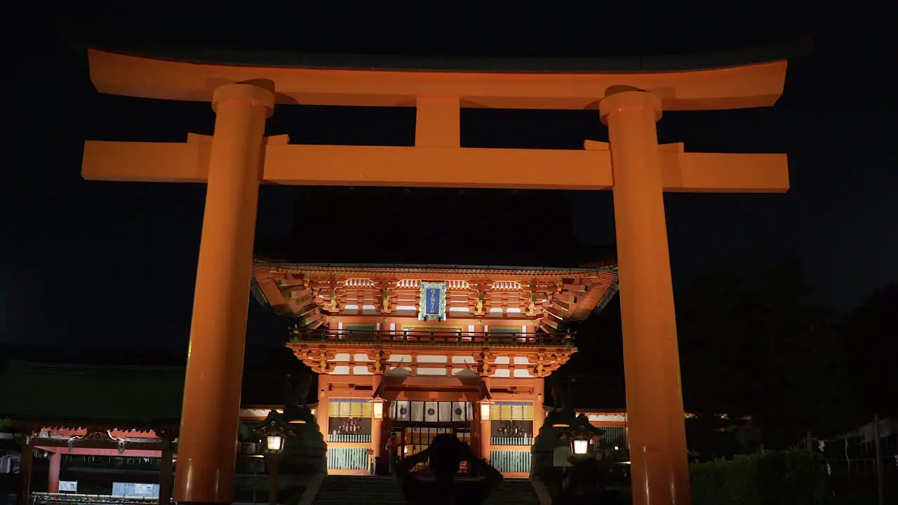 Wide view of the front gate area of the Fushimi Inari Shrine at night in Kyoto Japan