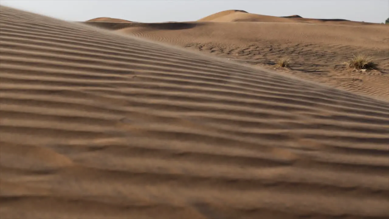 Slow motion sand blowing over middle east desert sand dunes