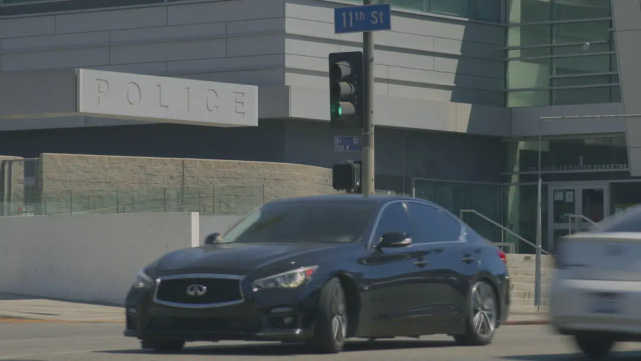 Static shot of cars passing the downtown police headquarters