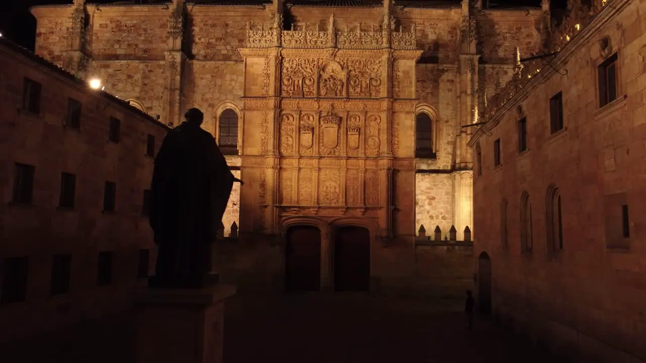 Historical neoclassical facade filled with engravings illuminated at night in Salamanca Spain