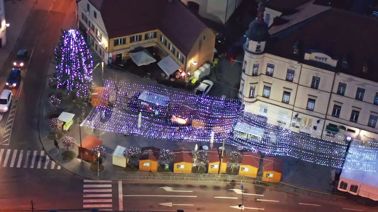 Christmas fair with decoration and bright lights on main square of small town in Europe aerial view of old medieval town center