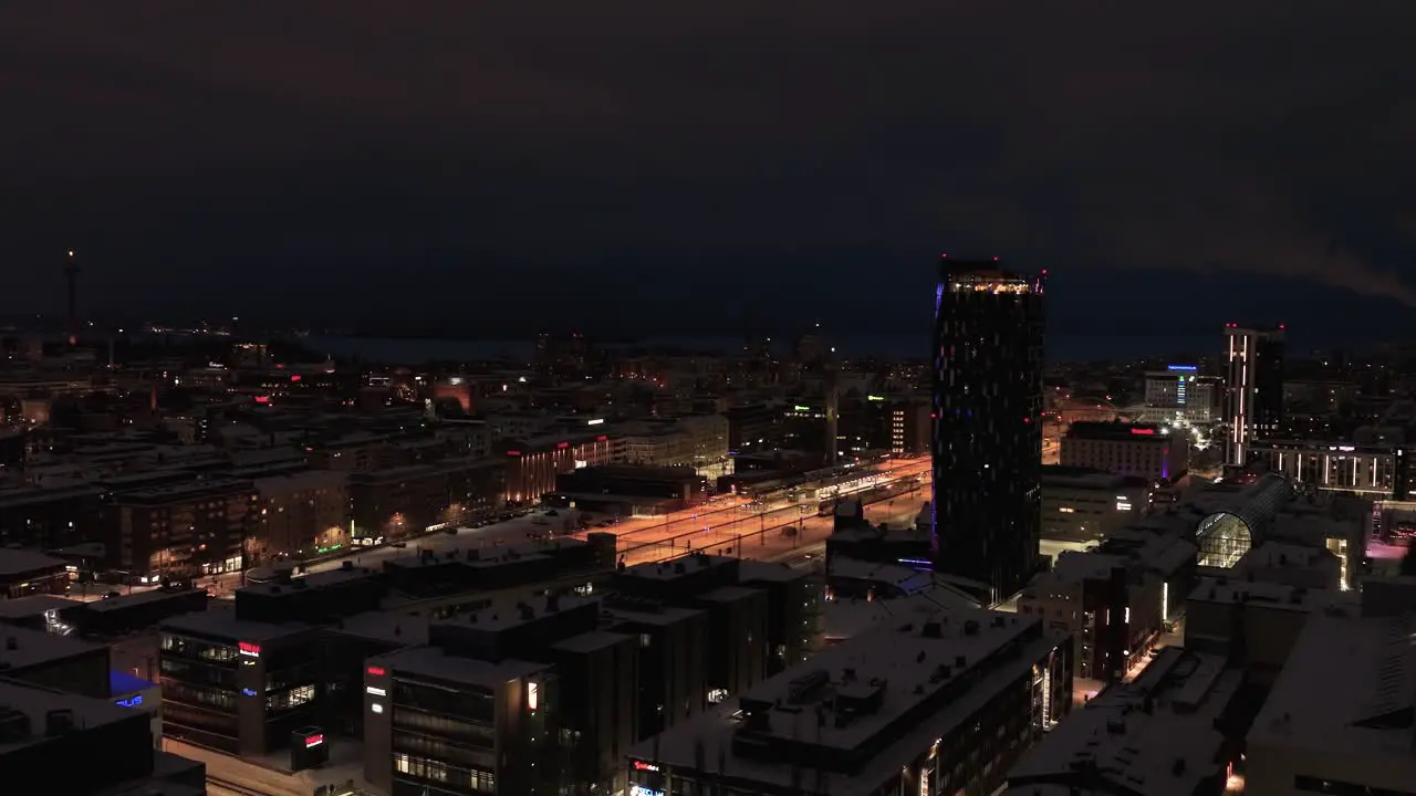 Aerial view tracking the lit downtown of Tampere Finland during a winter night