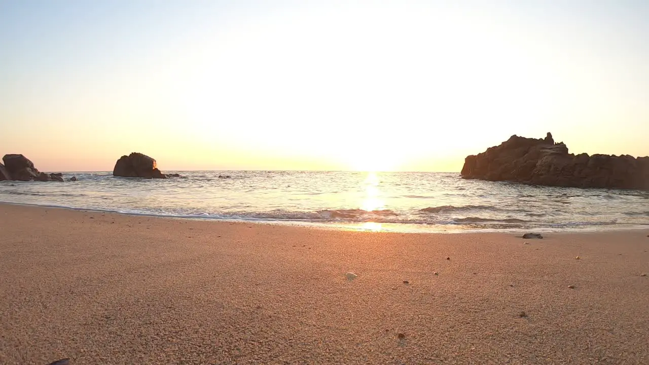 low Ground POV Calm ocean waves sound under warm sunset in Portuguese beach