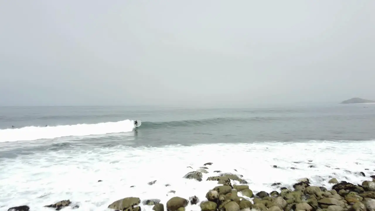 A surfer riding a wave then turning sharply out of it and letting the wave pass