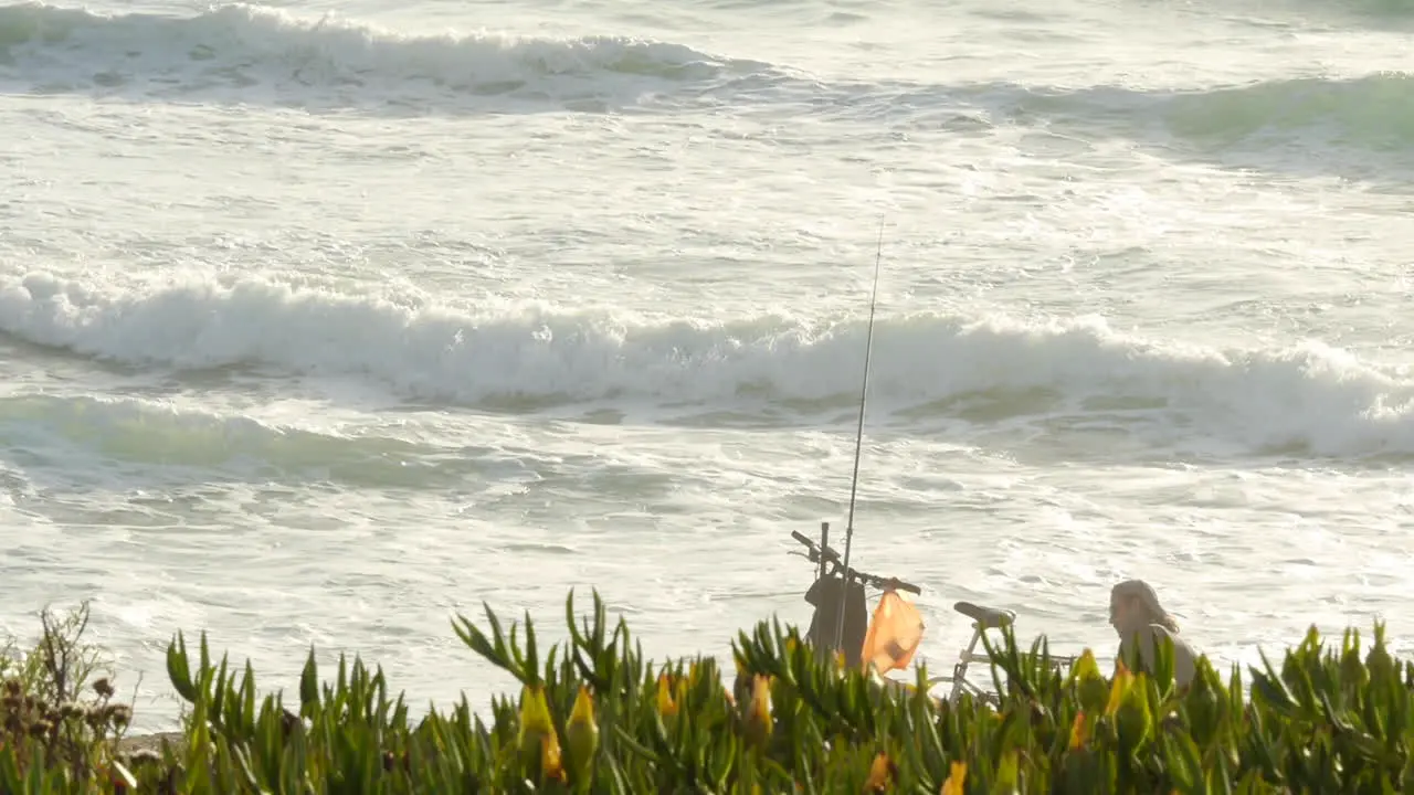 Fisherman Waits for Fish to Bite his Line Next to His Bicycle