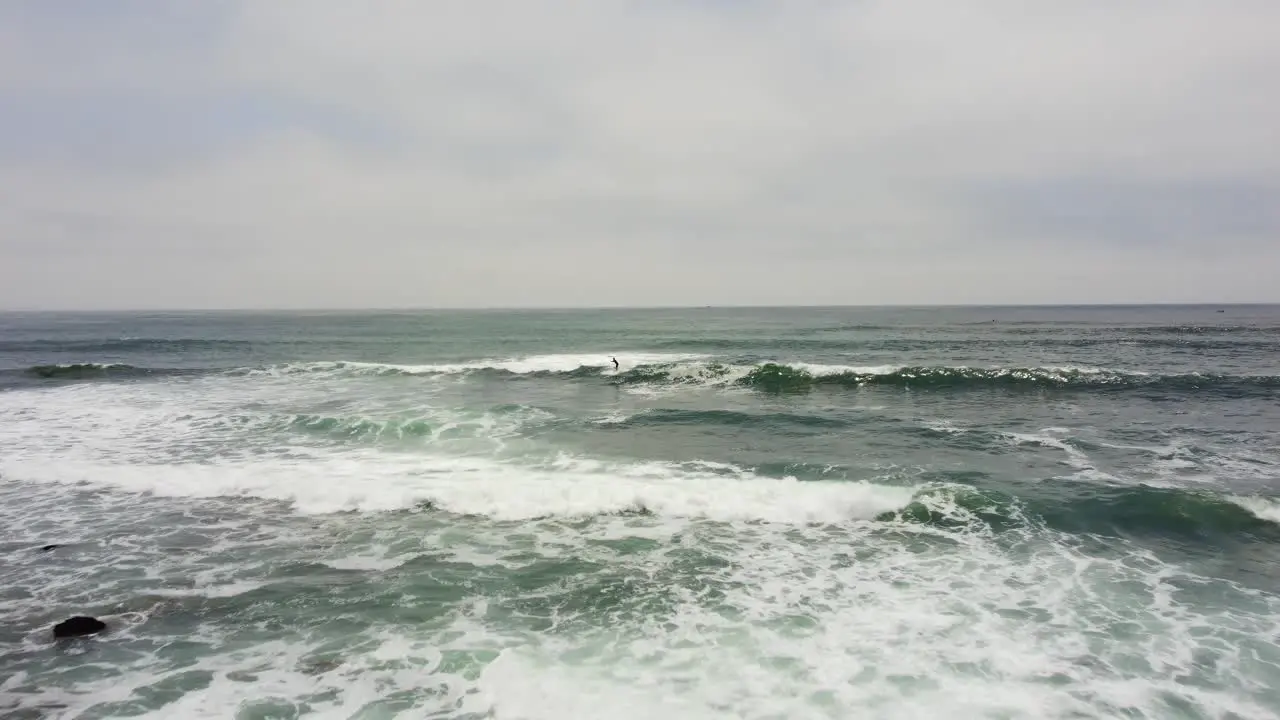 Drone footage of a surfer riding a wave