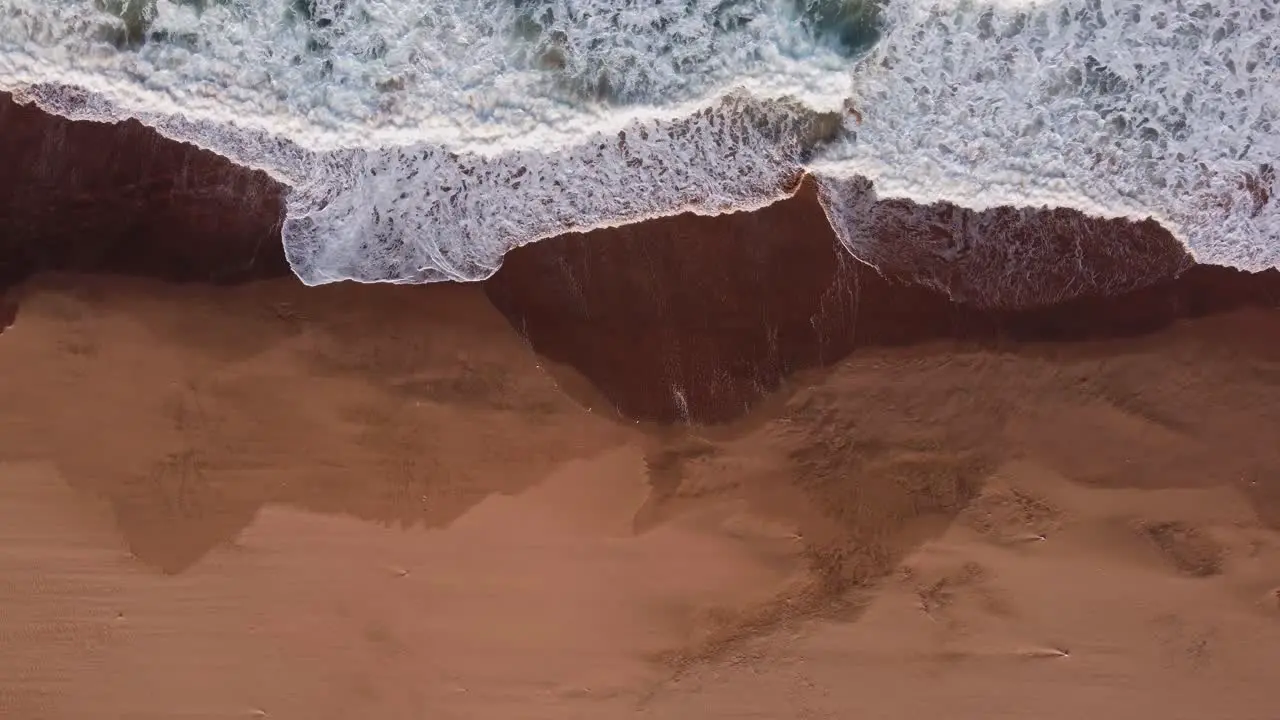 Waves of Indian Ocean hitting to Illovo beach in South Africa rising top down shot