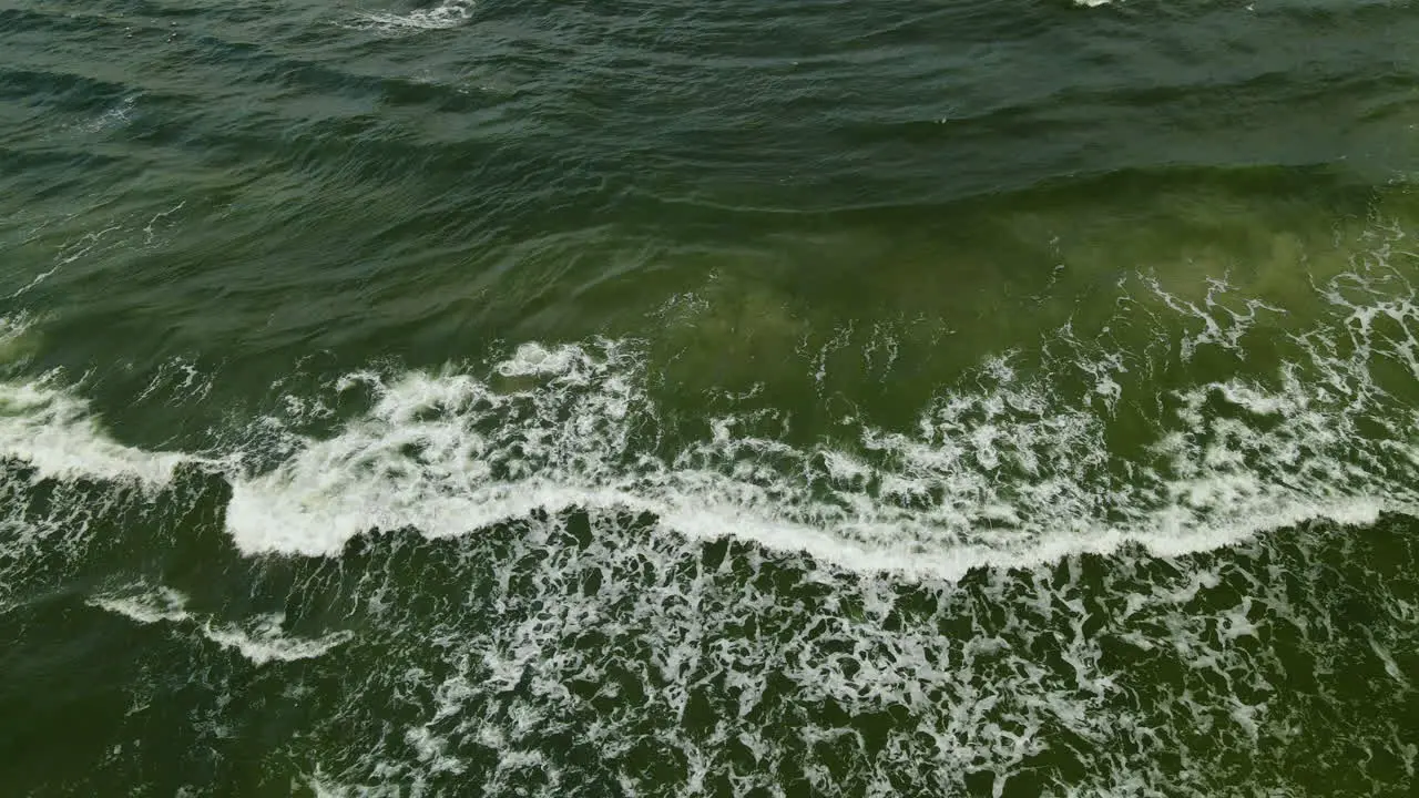 Green Ocean Waves Crash against the Shore Shot from Drone Aerial