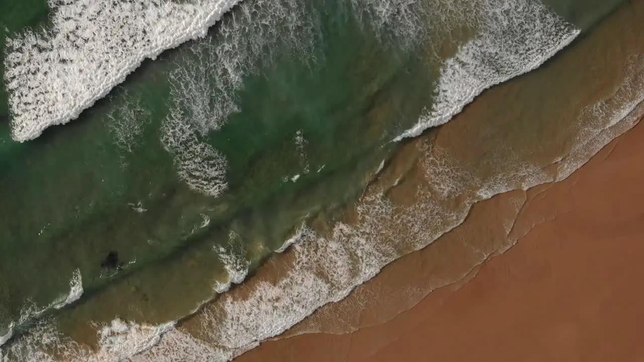 Calming waves break on idyllic golden sand beach