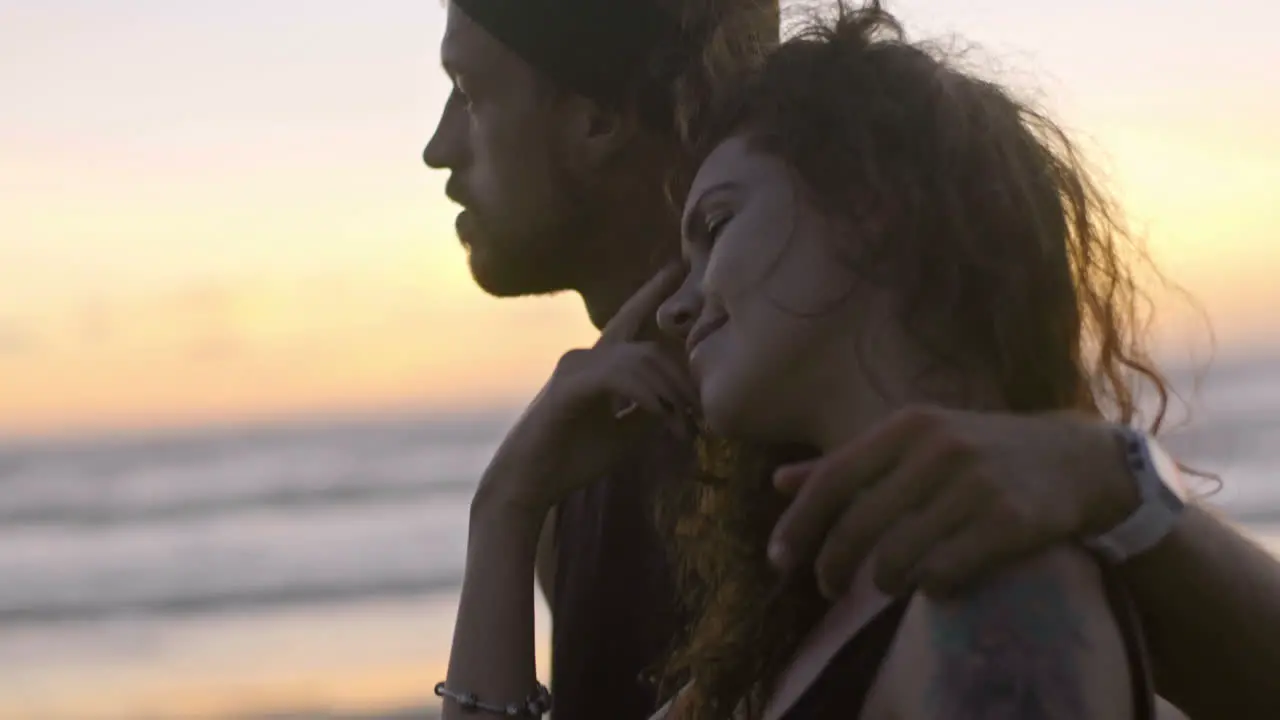 Couple Hugging Near A Motorbike On The Beach At Sunset