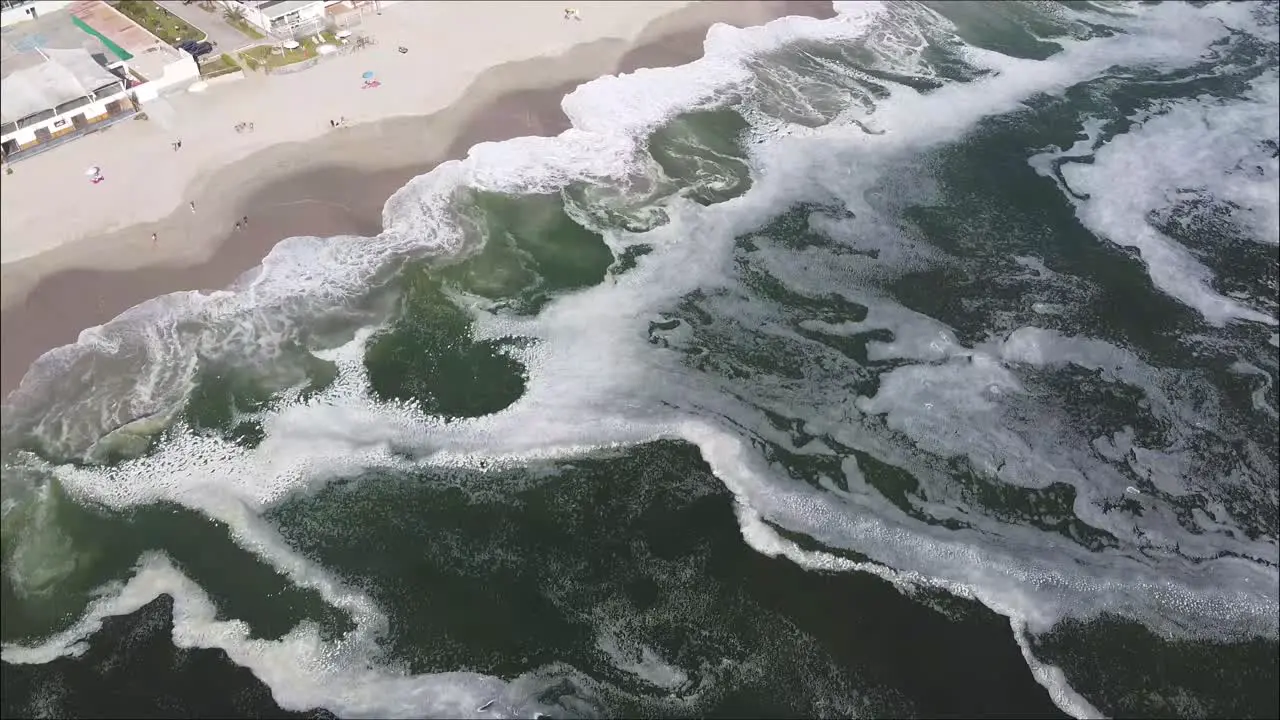 Top down drone shot of the ocean sand and beach houses in Peru