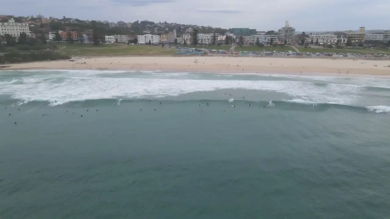 Bondi Beach With Surfers Riding The Waves With Eastern Suburbs In Background At Sydney New South Wales Australia