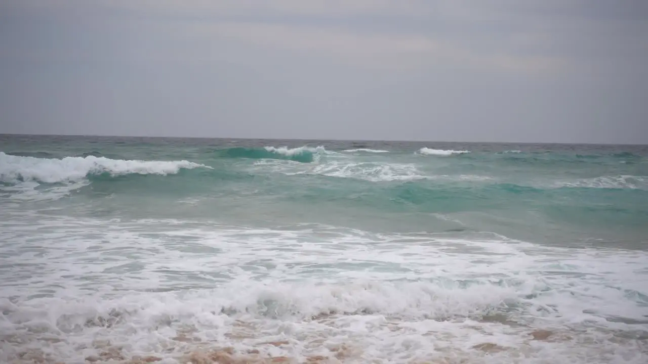 Ocean waves rolling into shore in Australia on an overcast and windy day