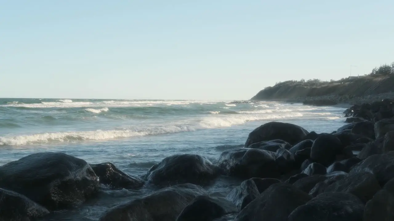 Morning light on sea coast with waves and stones on seaside