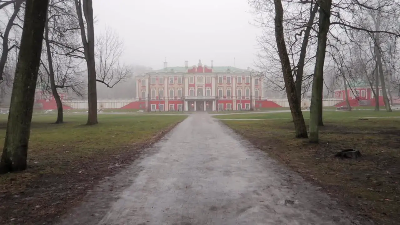 Forest road leading to kadriorg art museum in Tallinn park with fog and bad weather