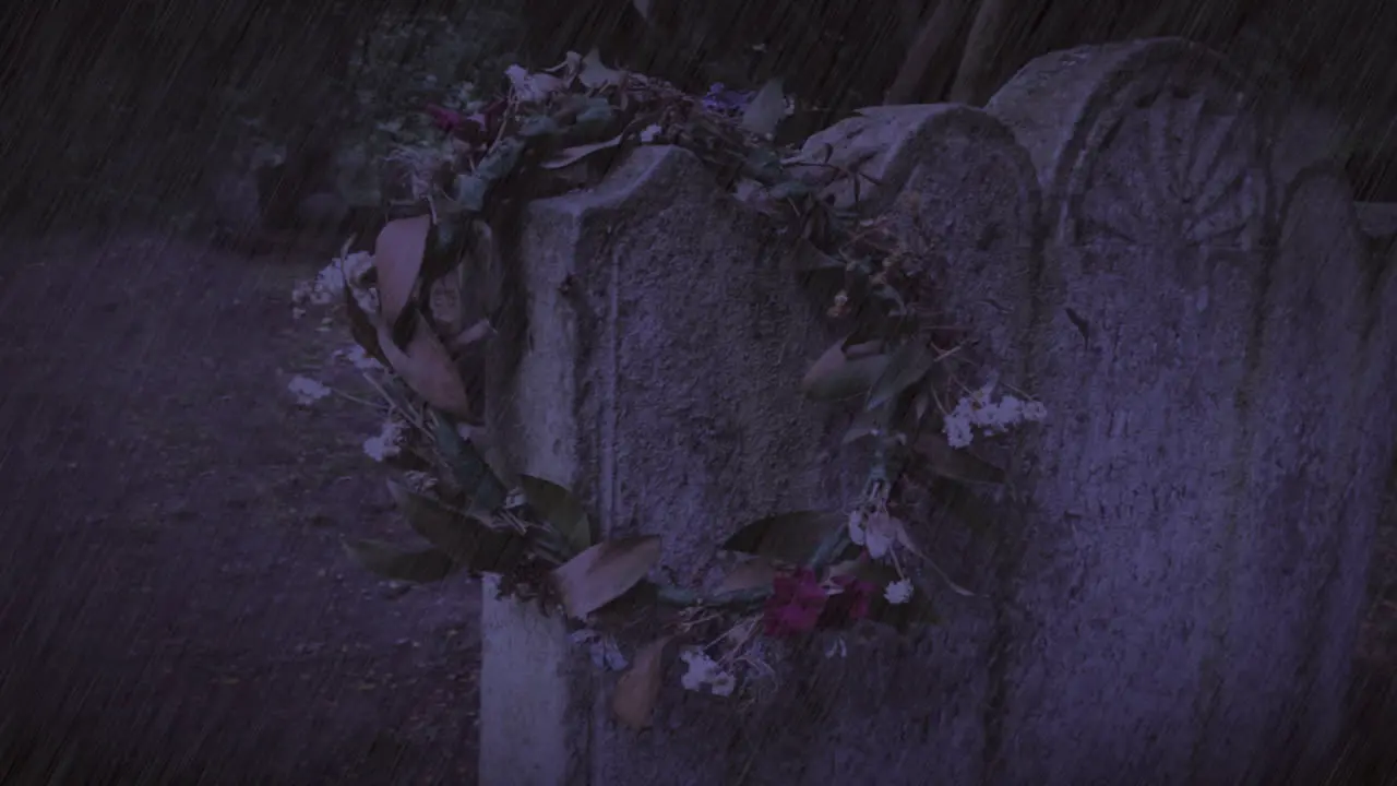 Withered wreath on ancient gravestone in thunderstorm