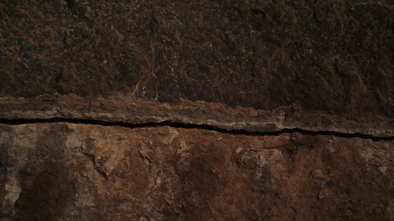 Close up sliding shot of Scary Cracked Rock stone inside the cave after hitting by the thunderbolt