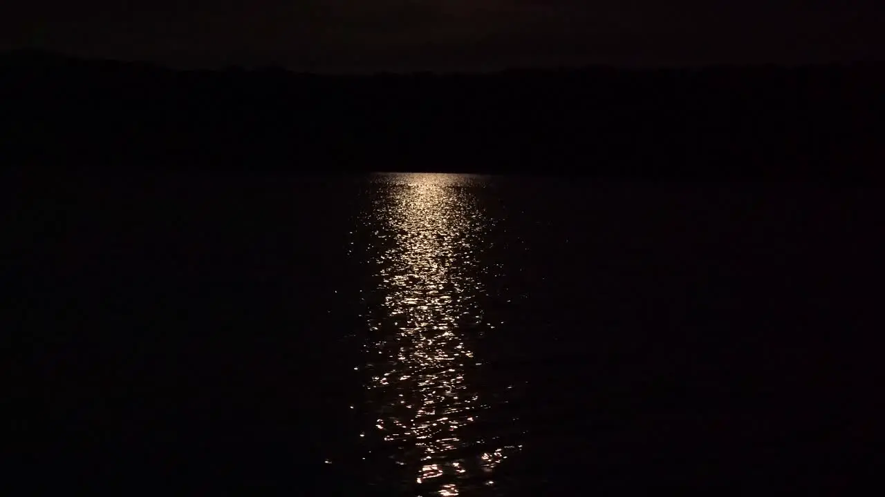 bright moon rays reflection on rippling lake water at night 4k