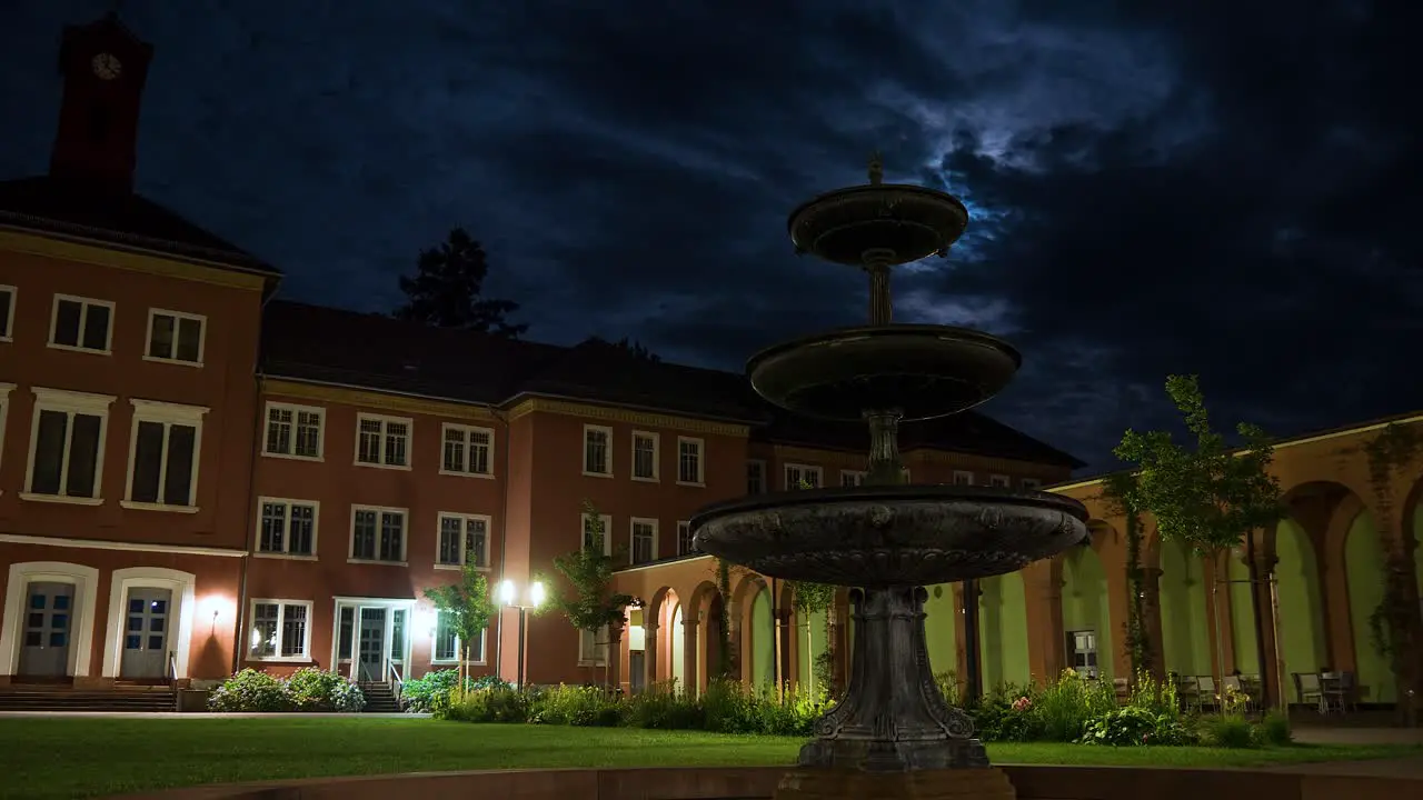 Time Lapse Shot of Old German Psychiatry at Night with Fountain in Foreground