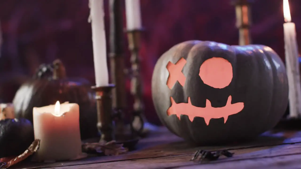 Video of halloween carved pumpkin candles and smoke with copy space on purple background