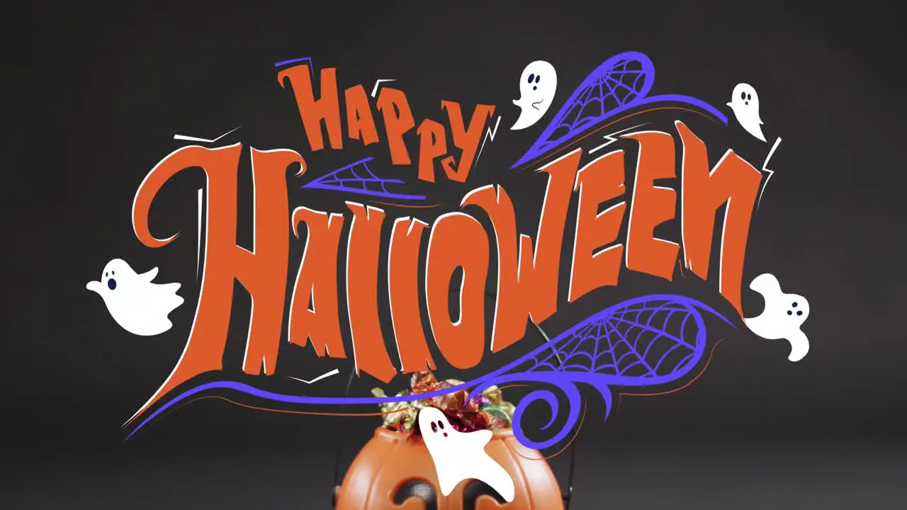 Animation of happy halloween text with ghosts over orange pumpkin bucket with sweets