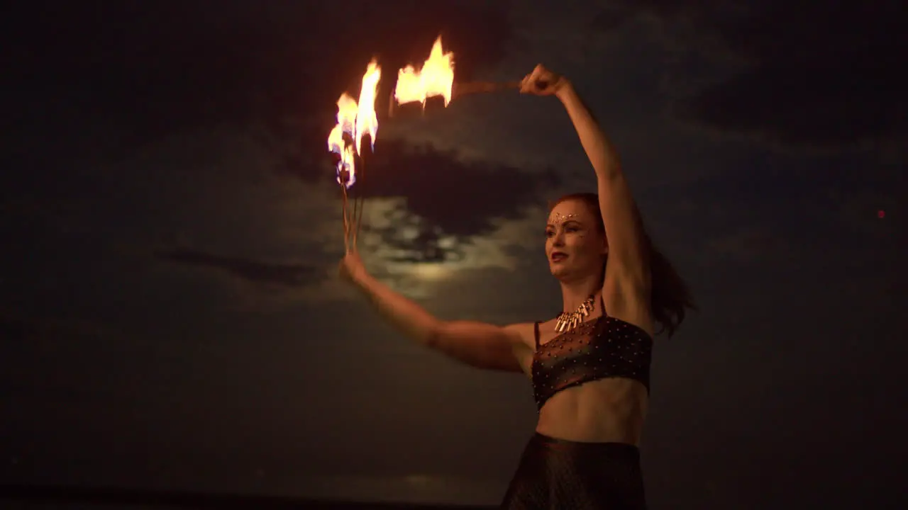 Woman Dancing With Fire Fans Against Cloudy Full Moon Night Sky Medium Shot Slowmo