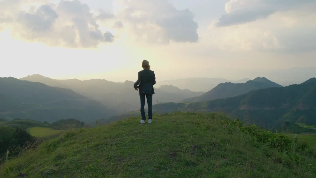 Slow motion shot of a woman holding a mid-autumn festival prop overlooking mountains