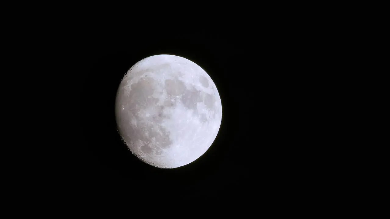 Supermoon begins to rise and open to full moon gentle zoom in behind foreground swiping past