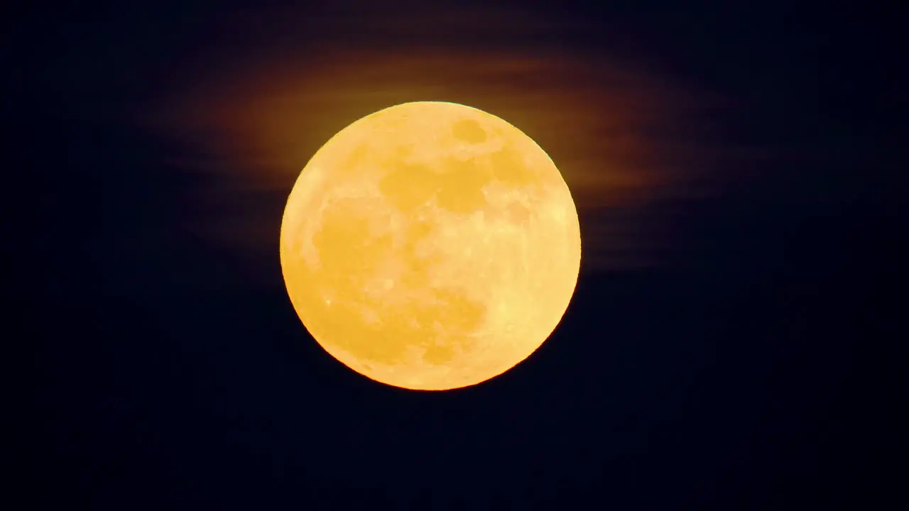 Rare full blue supermoon with orange gradient yellow hues and haze dark black sky