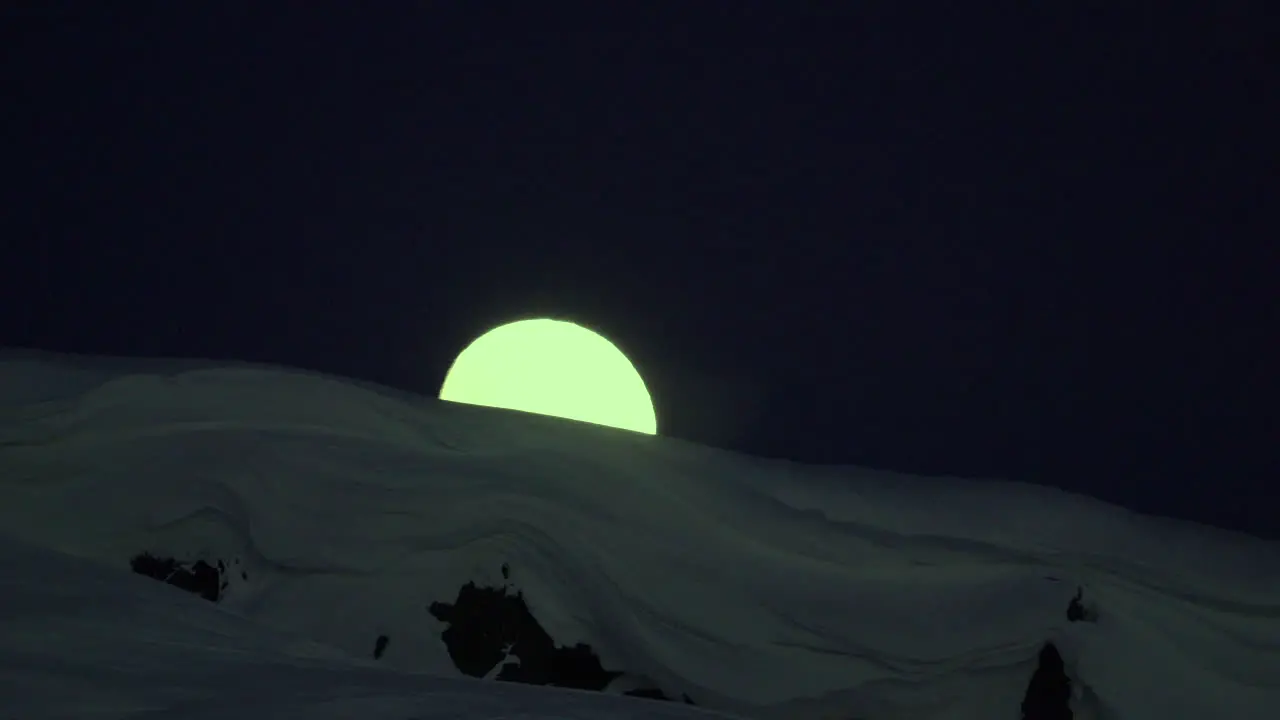 Stable tele zoom timelapse of moon rise behind mountain