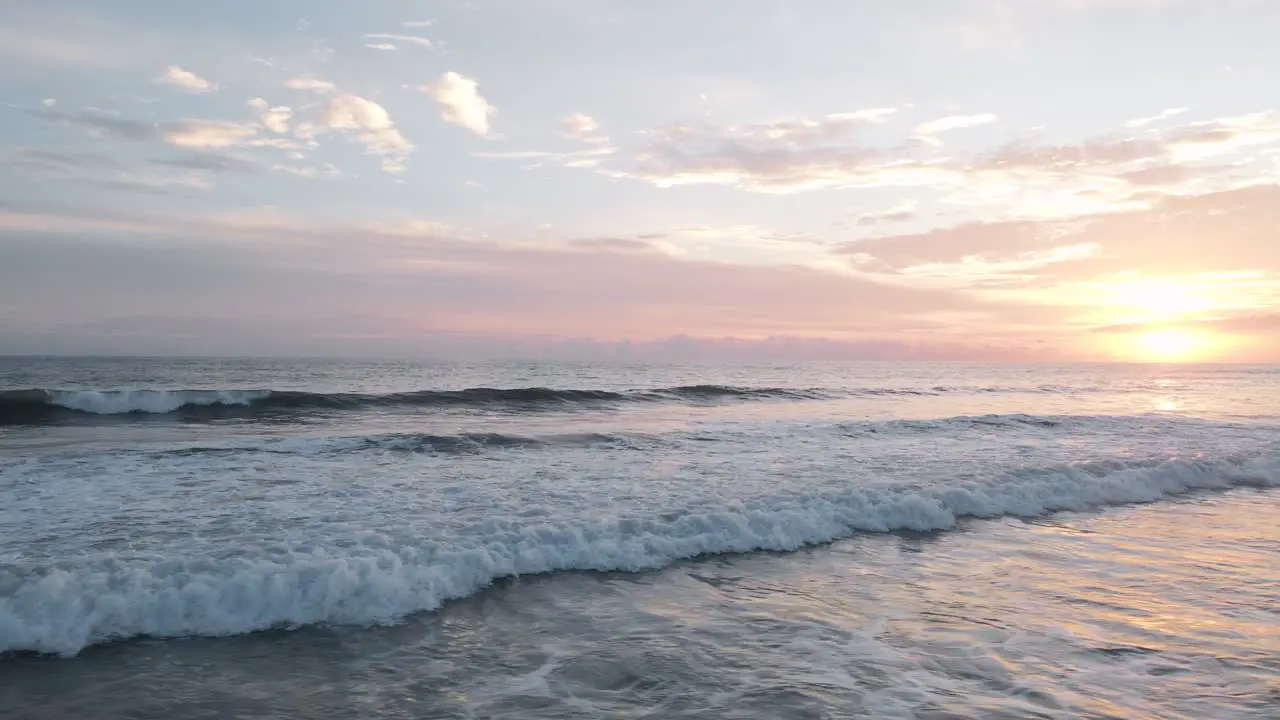 Aerial sliding shot over the white foaming surf of the pacific ocean on the beach of playa bandera in costa rica