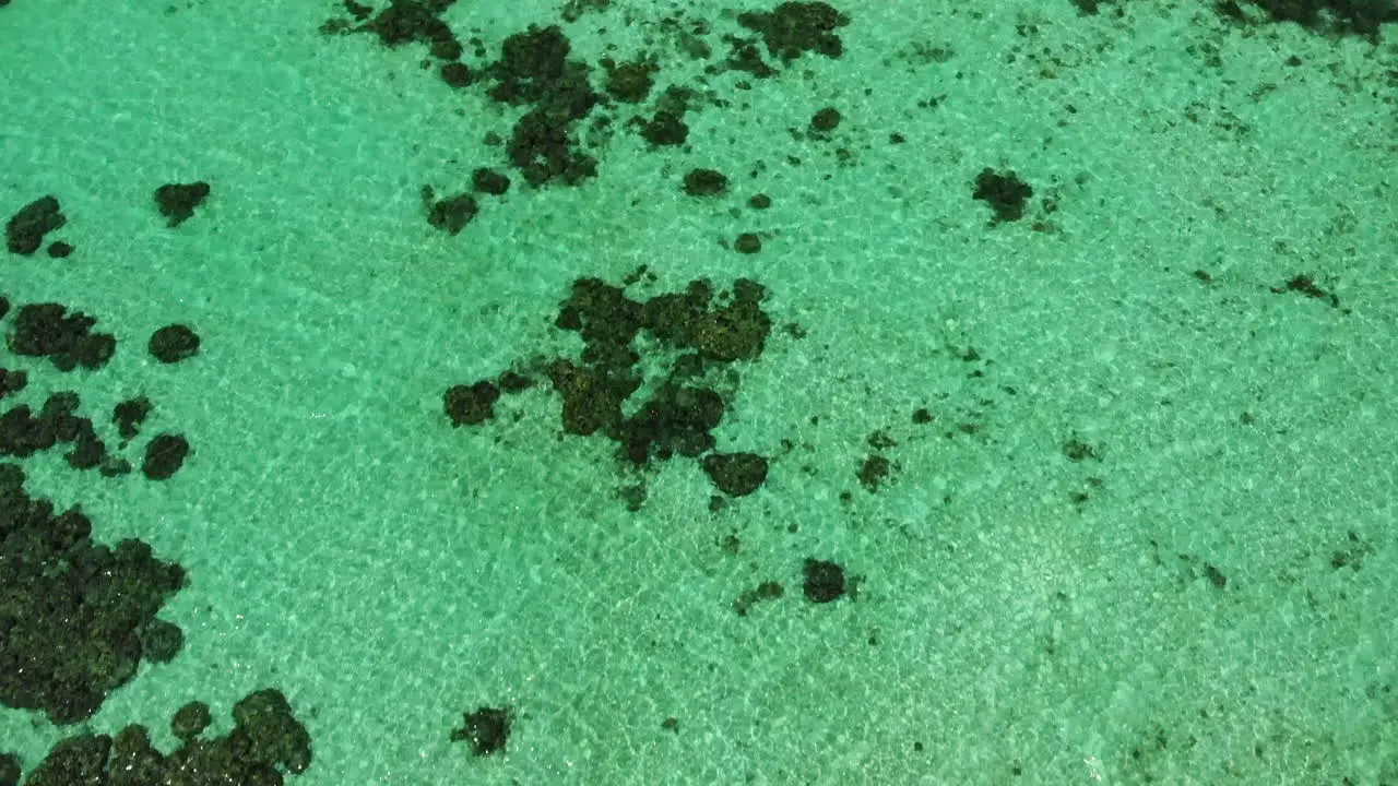 Top down view of the ocean with clear waters and a remote island in Thailand