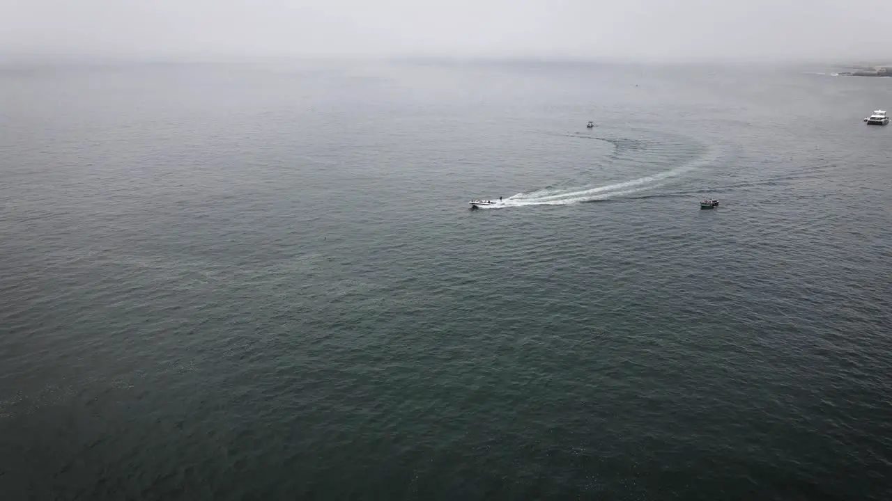 Drone shot of a person wakeboarding in the ocean in a boat in Lima Peru