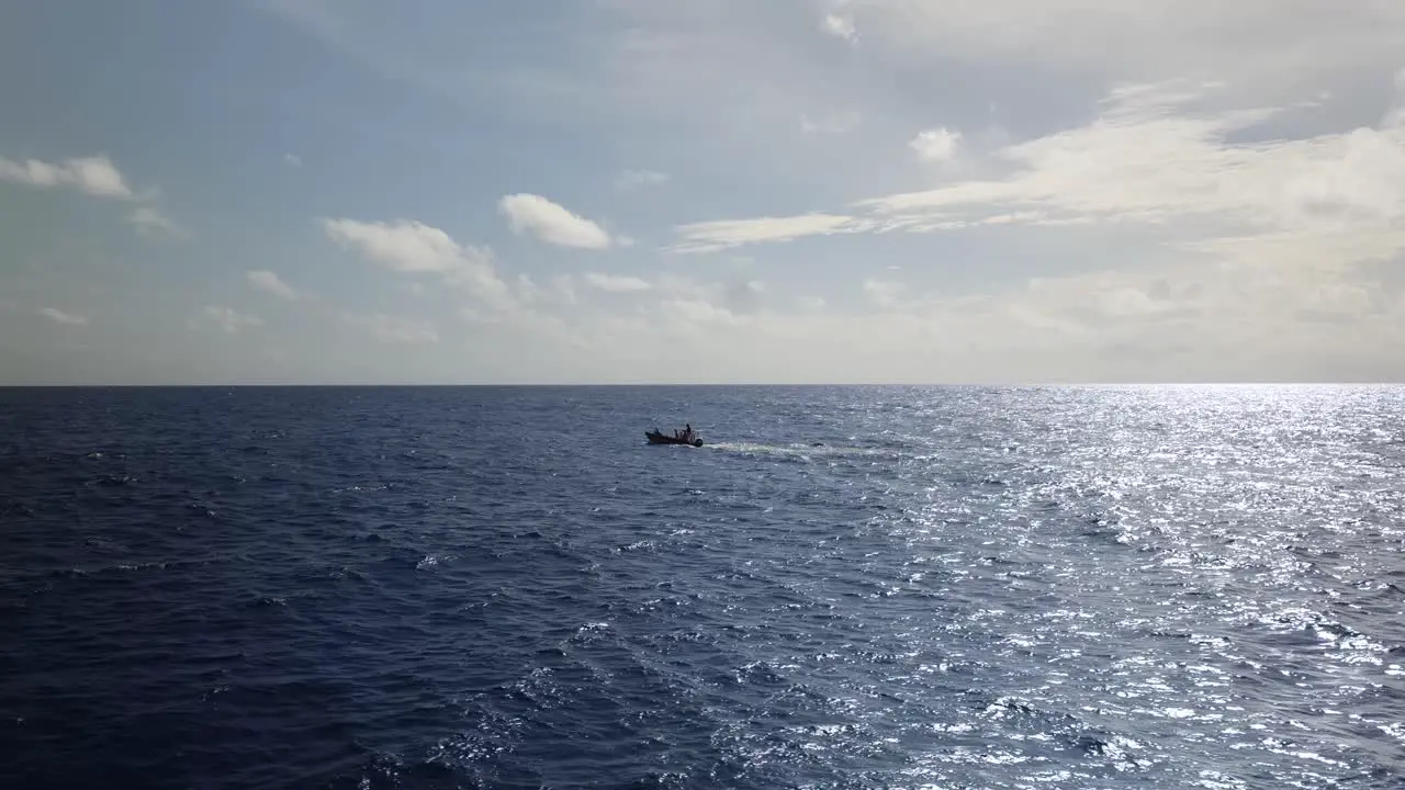 Motorboat driving in sun reflecting on the open ocean in 4k