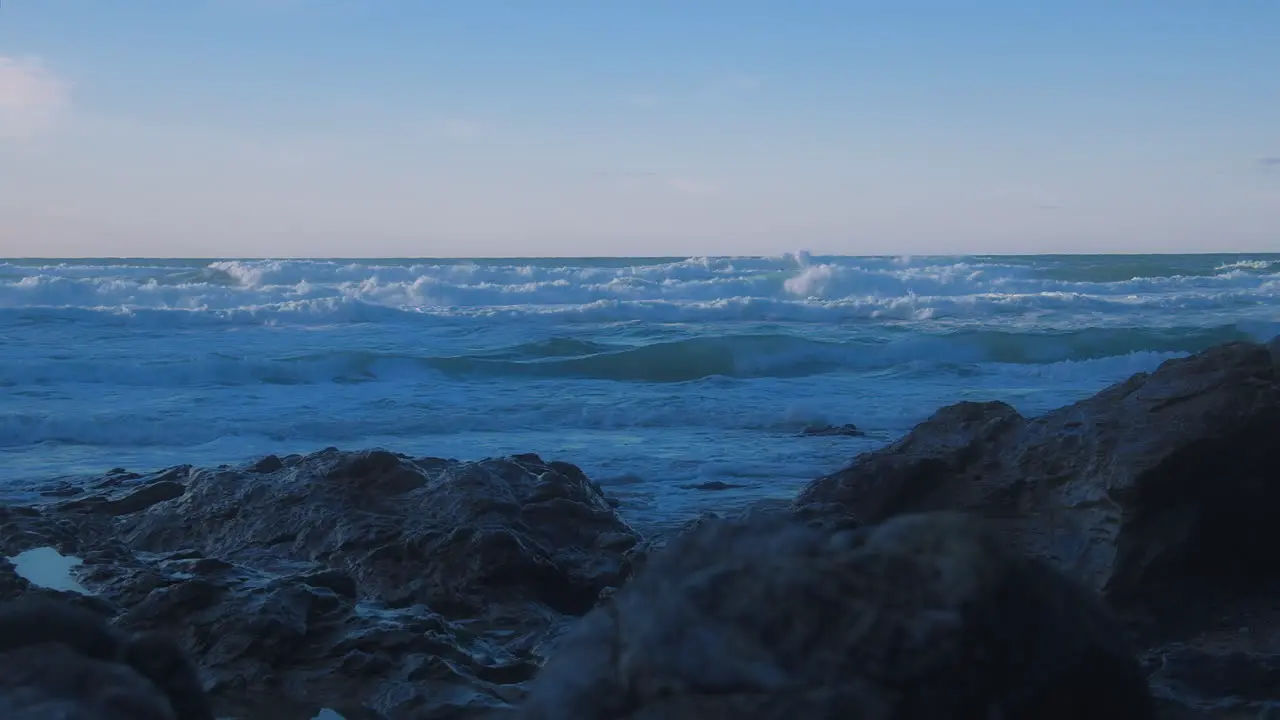 Parallax view toward choppy ocean horizon from rocky shore at Chapel Porth UK