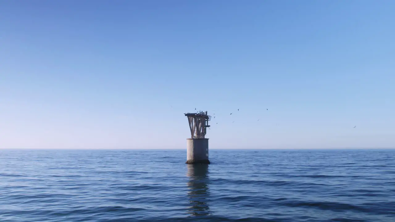 Empty abandoned tower in the Mediterranean Sea with seagulls flying around it