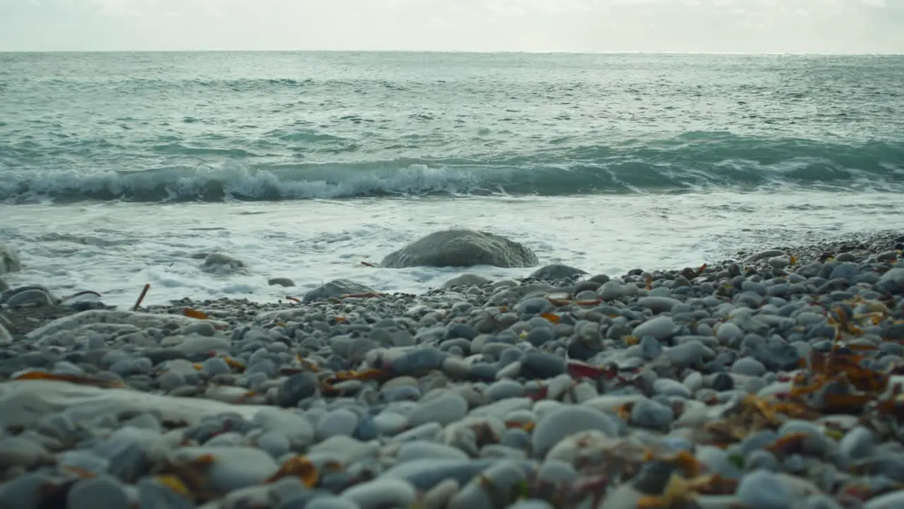 4K Slow motion cinematic scenery shot of waves hitting rocks on a pebble beach at Church Ope Portland Dorset in England