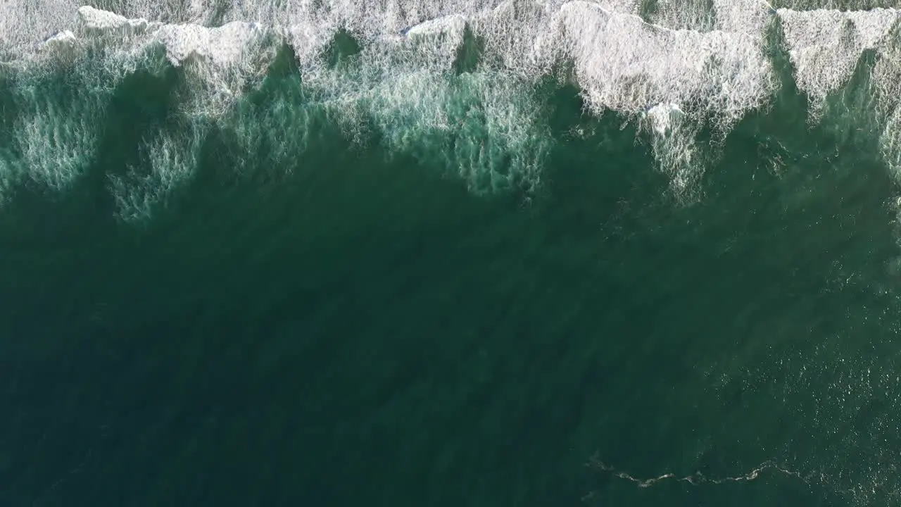 Birds Eye Flight Over Chindeguele Beach Showcasing Crashing Waves Beach and Sand Dunes