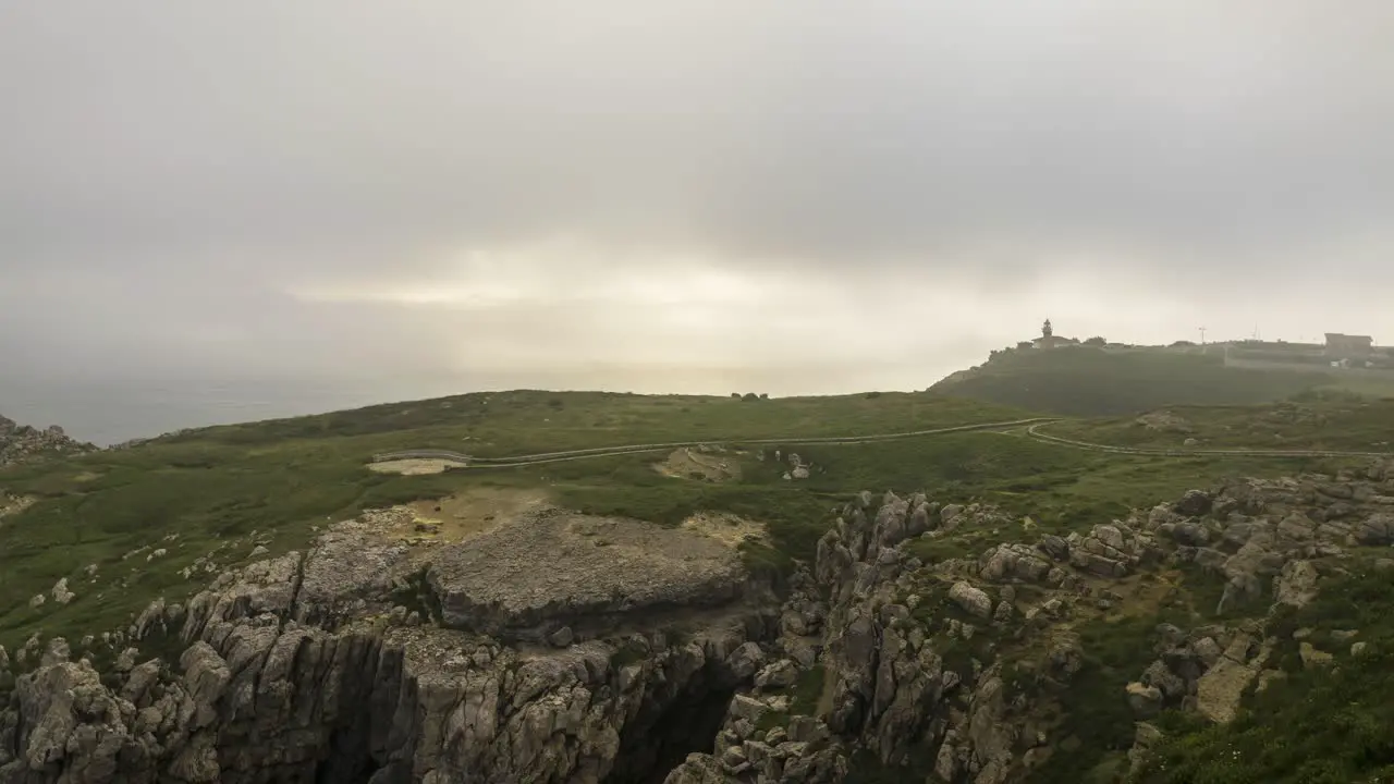 Clouds of fog over grassy cliff