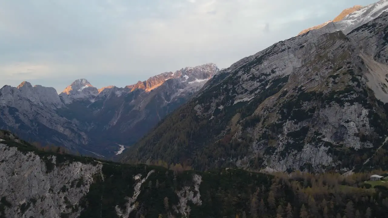 Aerial view of rough steep and dry mountains with sunlight falling on peak during sunrise