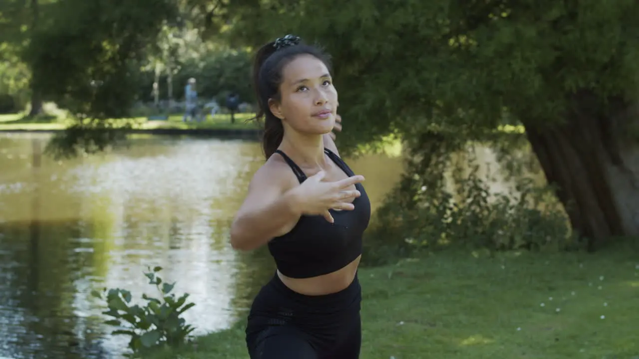 Young woman doing warrior pose while exercising yoga