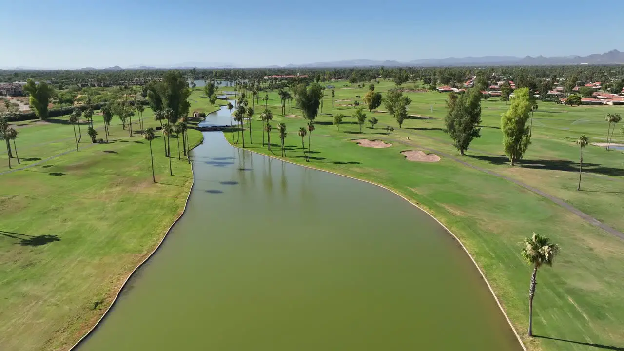 Golf course lined with palm trees and water feature