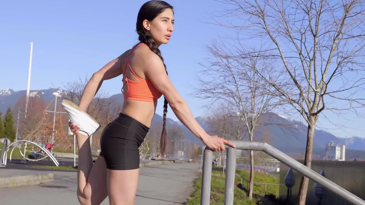 Athletic young woman stretching legs before morning run Medium shot