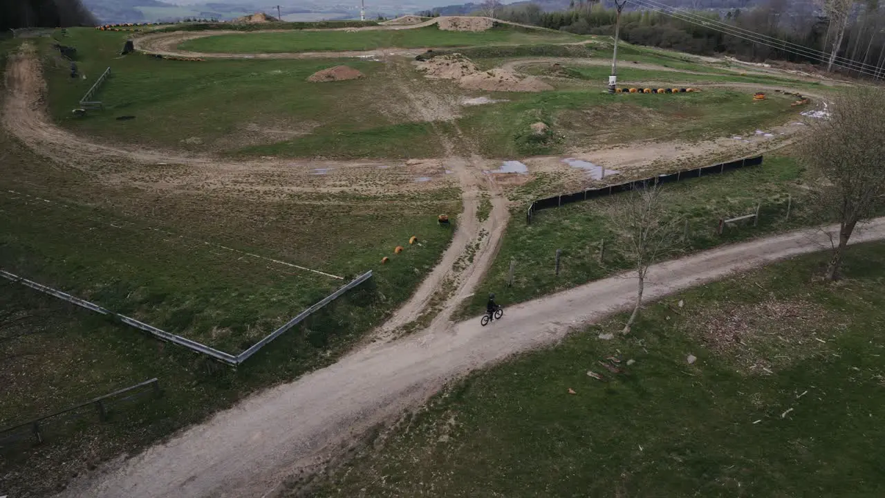 Aerial shot of a motocross track with a boy riding his bike around it