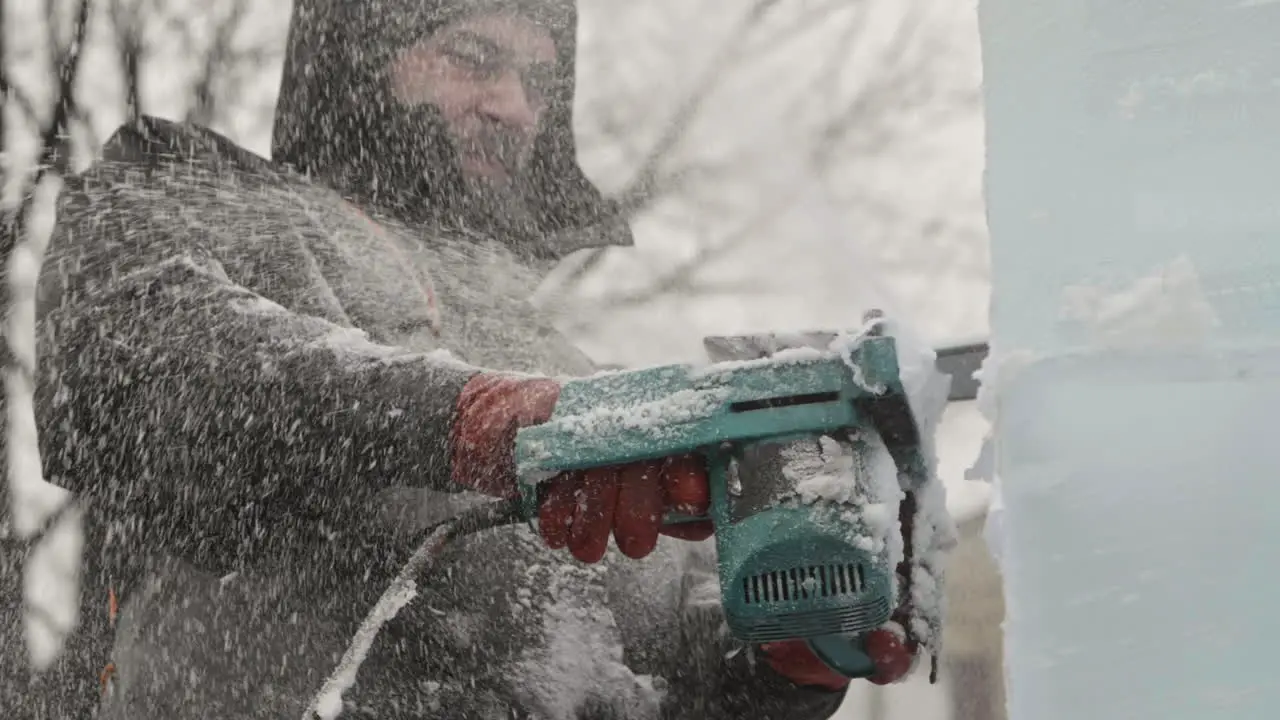 Ice chips and shavings spraying out of ice sculpture as artist uses electric chainsaw Slow Motion