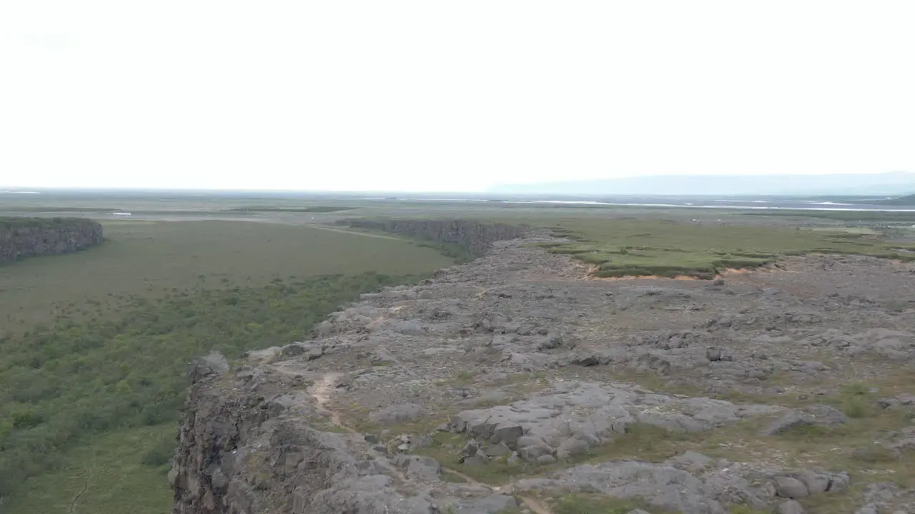 Rock edge at Asbyrgi canyon in Iceland with bright cloudy sky aerial