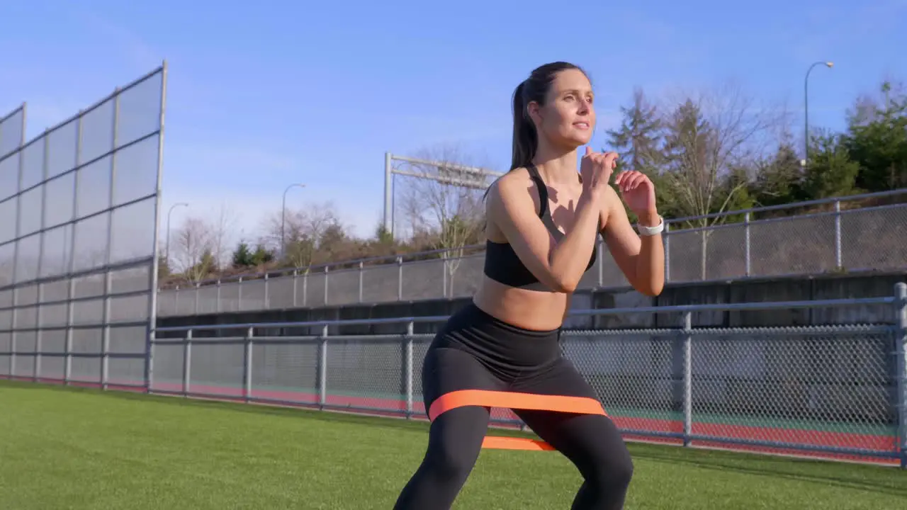 Female athlete walking squat exercise using resistance band