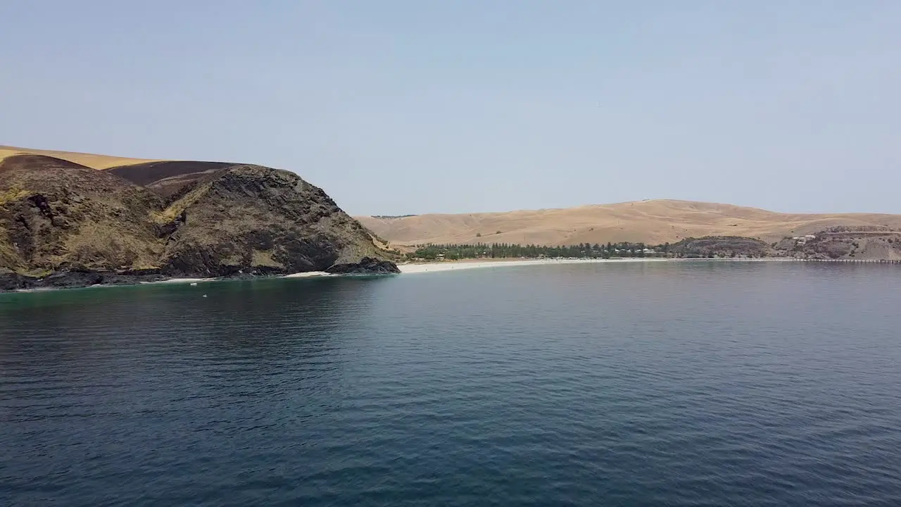 Flying over the waves of Rapid Bay towards the mountain shoreline aerial